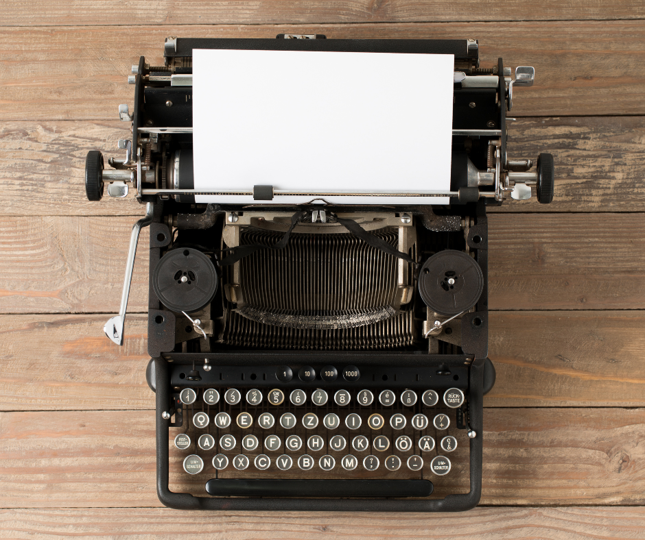 Old fashioned black typewriter with a wood background.