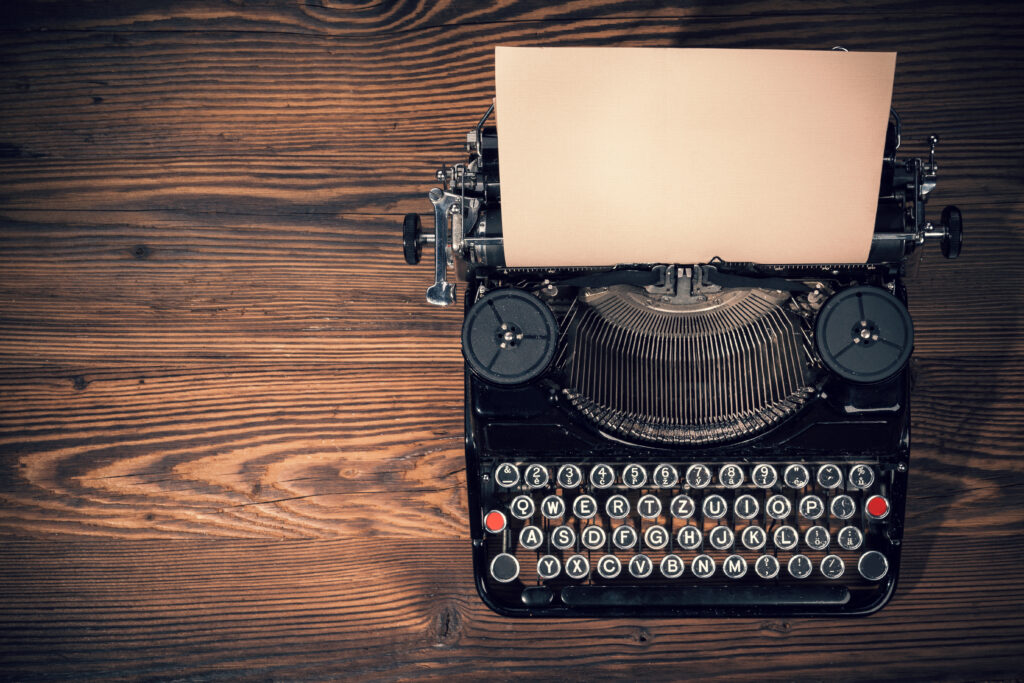 Retro typewriter placed on wooden planks. Aerial angle of view